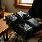 Elegant gift wrapped in Wrapped Studios floral wrapping paper with a black ribbon.