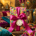 Luxury boho floral wrapping paper with a magenta satin bow and tag by Wrapped Studios.