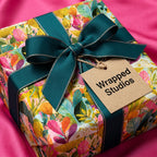 Luxury botanical floral wrapping paper by Wrapped Studios on a gift box with a teal ribbon.