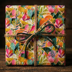 Colorful botanical floral wrapping paper with a rustic twine bow on a gift box, by Wrapped Studios.