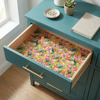 Vibrant floral wrapping paper used as a drawer liner in a teal dresser. By Wrapped Studios.