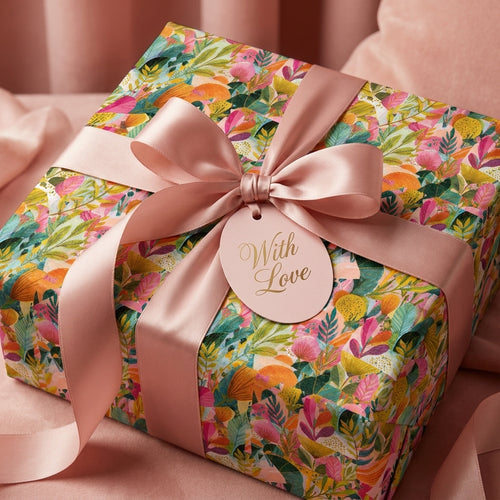 Luxury floral wrapping paper with a pink satin ribbon and "With Love" gift tag by Wrapped Studios.
