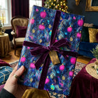 Luxury Christmas gift wrap with pink ornament pattern and purple velvet ribbon by Wrapped Studios.