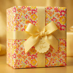 Floral wrapping paper on a gift box with yellow ribbon and "For You" tag.