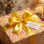 Wrapped Studios floral wrapping paper with yellow ribbon.