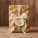 Elegant gift wrapped in gold abstract wrapping paper with a cream ribbon and tag.