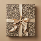 Elegant floral wrapping paper on a square gift box with a cream satin ribbon and bow.