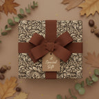 Elegant floral gift wrapped in decorative wrapping paper with a brown ribbon and “A Special Gift” tag.