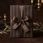 Elegant brown striped wrapping paper with matching luxury satin ribbon and Wrapped Studios tag.