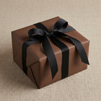 Elegant brown gift box wrapped in solid paper with a black ribbon and bow, perfect for birthdays or special occasions.
