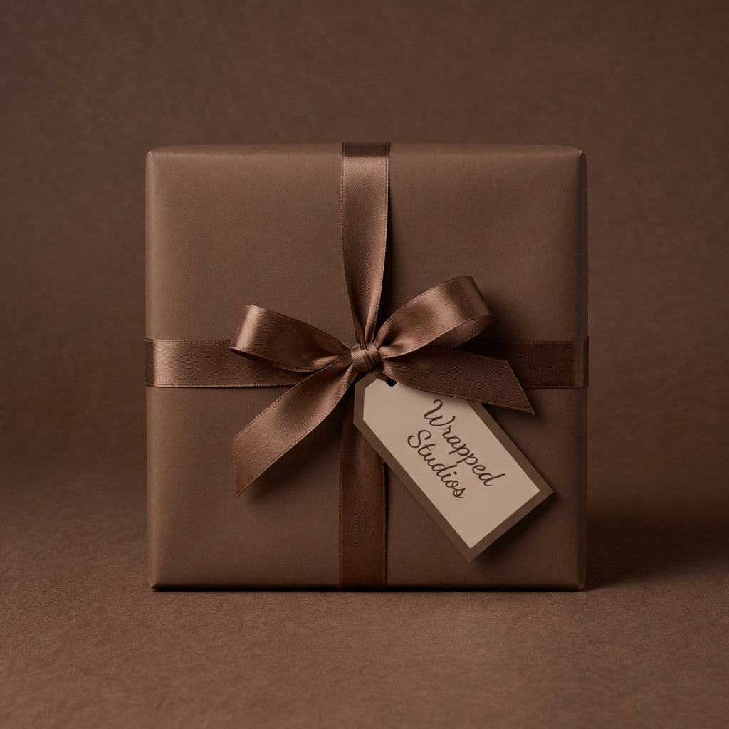 Elegant brown wrapping paper on square gift box with satin ribbon and gift tag.