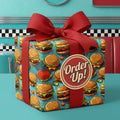 Funky gift wrapped in burger-themed birthday wrapping paper with a red ribbon and "Order Up!" tag.