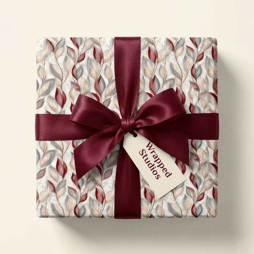 Elegant burgundy botanical wrapping paper with a luxury satin bow on a gift box by Wrapped Studios.