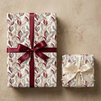 Elegant floral wrapping paper with burgundy leaves and satin ribbons on gifts by Wrapped Studios.