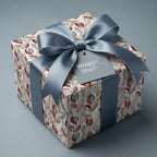 Luxury botanical wrapping paper in blue and burgundy with a matching satin ribbon bow by Wrapped Studios.