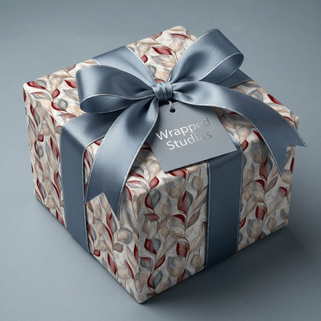 Luxury botanical wrapping paper in blue and burgundy with a matching satin ribbon bow by Wrapped Studios.