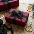 Burgundy wrapping paper with black ribbon, perfect for elegant Christmas or holiday gifts.