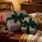 Striped Christmas gift wrap with green velvet ribbon bows on presents in a warm, elegant setting.