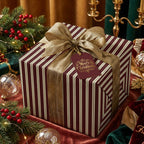 Elegant Christmas gift wrapped in burgundy striped paper with gold ribbon and "Merry Christmas" tag.
