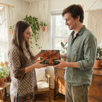Couple holding a gift in green botanical floral wrapping paper with a terracotta ribbon by Wrapped Studios.