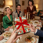 Luxury Christmas wrapping paper with a red velvet bow at a holiday dinner party. Gift wrap by Wrapped Studios.