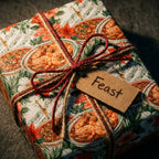 Seafood feast wrapping paper with a rustic twine bow and gift tag on a present by Wrapped Studios.