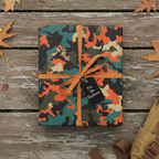 Camouflage wrapping paper gift, tied with ribbon, tag reads "For the Explorer."