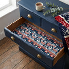 Canadian winter cabin wrapping paper lining a navy blue dresser drawer, by Wrapped Studios.