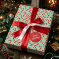 Mint green candy cane Christmas wrapping paper by Wrapped Studios, tied with a red satin bow.