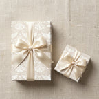 Elegant wedding wrapping paper with white dove pattern and cream satin bows by Wrapped Studios.