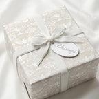 Elegant baptism wrapping paper with dove pattern and white velvet ribbon by Wrapped Studios.