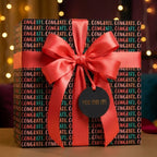 Congrats graduation wrapping paper with coral satin bow and 'You did it' tag by Wrapped Studios.