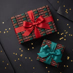 Black congratulations wrapping paper with red and teal bows on gold confetti, by Wrapped Studios.