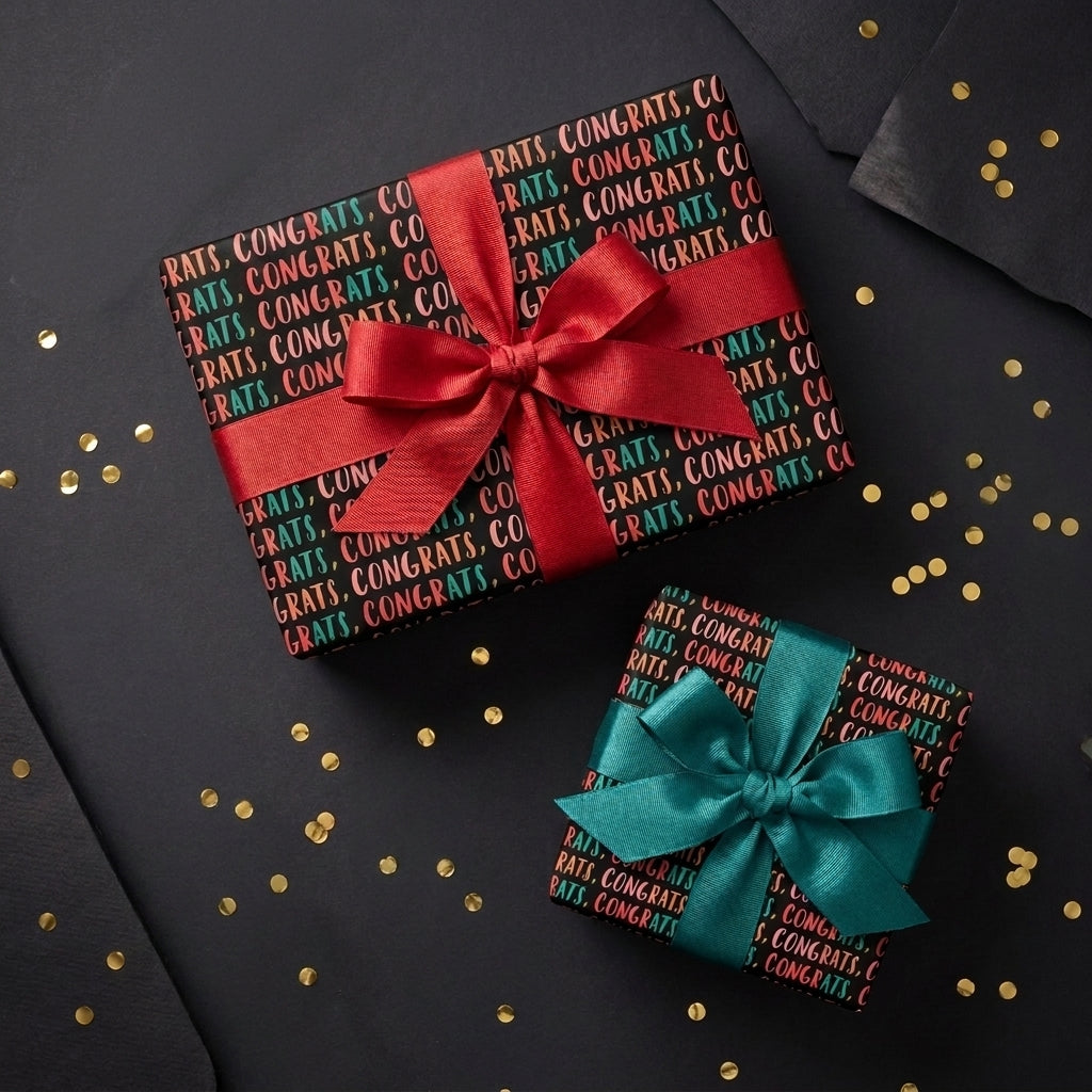 Black congratulations wrapping paper with red and teal bows on gold confetti, by Wrapped Studios.