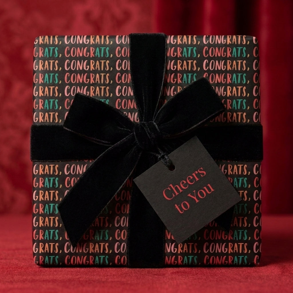 Congratulations wrapping paper with a black velvet bow and "Cheers to You" tag by Wrapped Studios.
