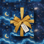 Square gift wrapped in celestial moon and stars wrapping paper with gold ribbon.