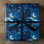 Square gift wrapped in celestial-themed paper with moon and stars, tied with black ribbon.