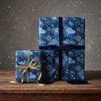 Navy celestial wrapping paper with gold sun, moon, and stars design, tied with velvet and metallic ribbon.