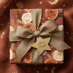 Terracotta boho floral wrapping paper with gold ribbon on a gift box, by Wrapped Studios.