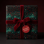 Luxury starry Christmas wrapping paper in forest green with a red velvet bow, by Wrapped Studios.