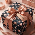 Luxury celestial starburst wrapping paper in navy and rose gold with satin bow, by Wrapped Studios.