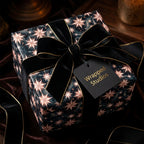Luxury celestial star wrapping paper with a black velvet bow by Wrapped Studios.