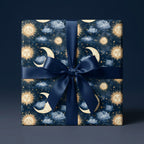 Celestial wrapping paper with a gold sun and moon pattern and navy satin ribbon by Wrapped Studios.
