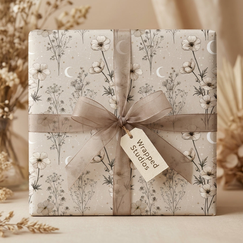 Boho celestial floral wrapping paper by Wrapped Studios with moons, wildflowers, and a sheer taupe ribbon.
