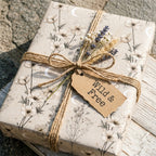 Celestial floral wrapping paper with moons, tied with twine and lavender on a rustic gift by Wrapped Studios.