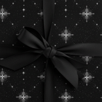 Elegant black gift box wrapped in luxury star-patterned wrapping paper with a satin ribbon.
