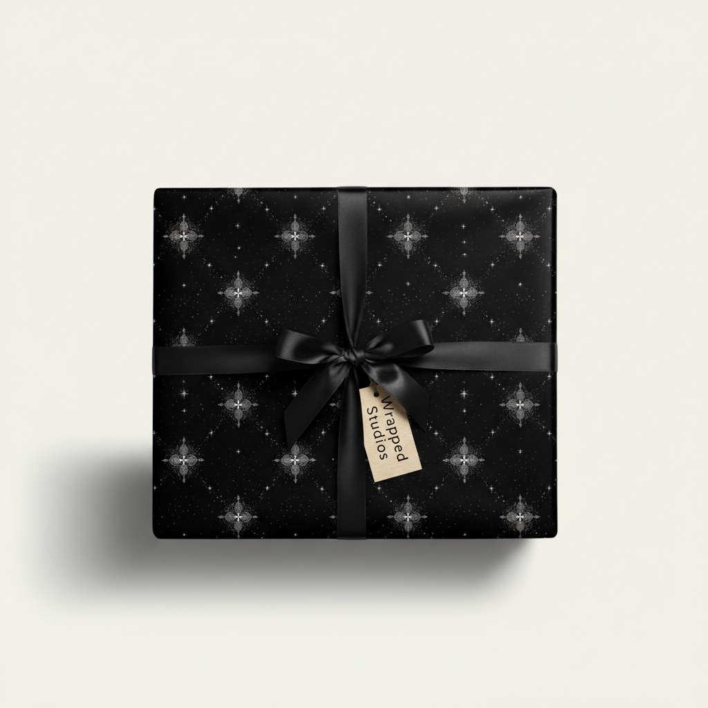 Elegant gift wrapped in black luxury wrapping paper with a silver star pattern and a black satin ribbon.