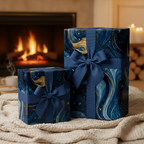 Elegant navy and gold luxury gift wrap with blue ribbon, sitting near a cozy fireplace.