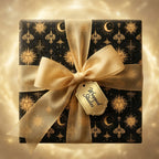 Luxury black and gold celestial wrapping paper with sun and moon motifs and a gold bow by Wrapped Studios.