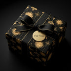 Luxury celestial wrapping paper in black and gold with a black ribbon by Wrapped Studios.